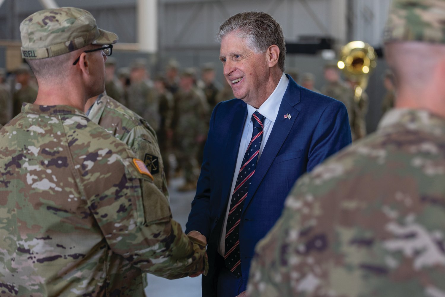 DEPLOYMENT: A deploying guardsman shakes hands with Gov. Dan McKee as the Rhode Island National Guard hosted a departure ceremony for Alpha Company, 1-182nd Infantry Battalion, nicknamed “Attack” Company, at the Army Aviation Support Facility on Quonset Air National Guard Base on Memorial Day. 